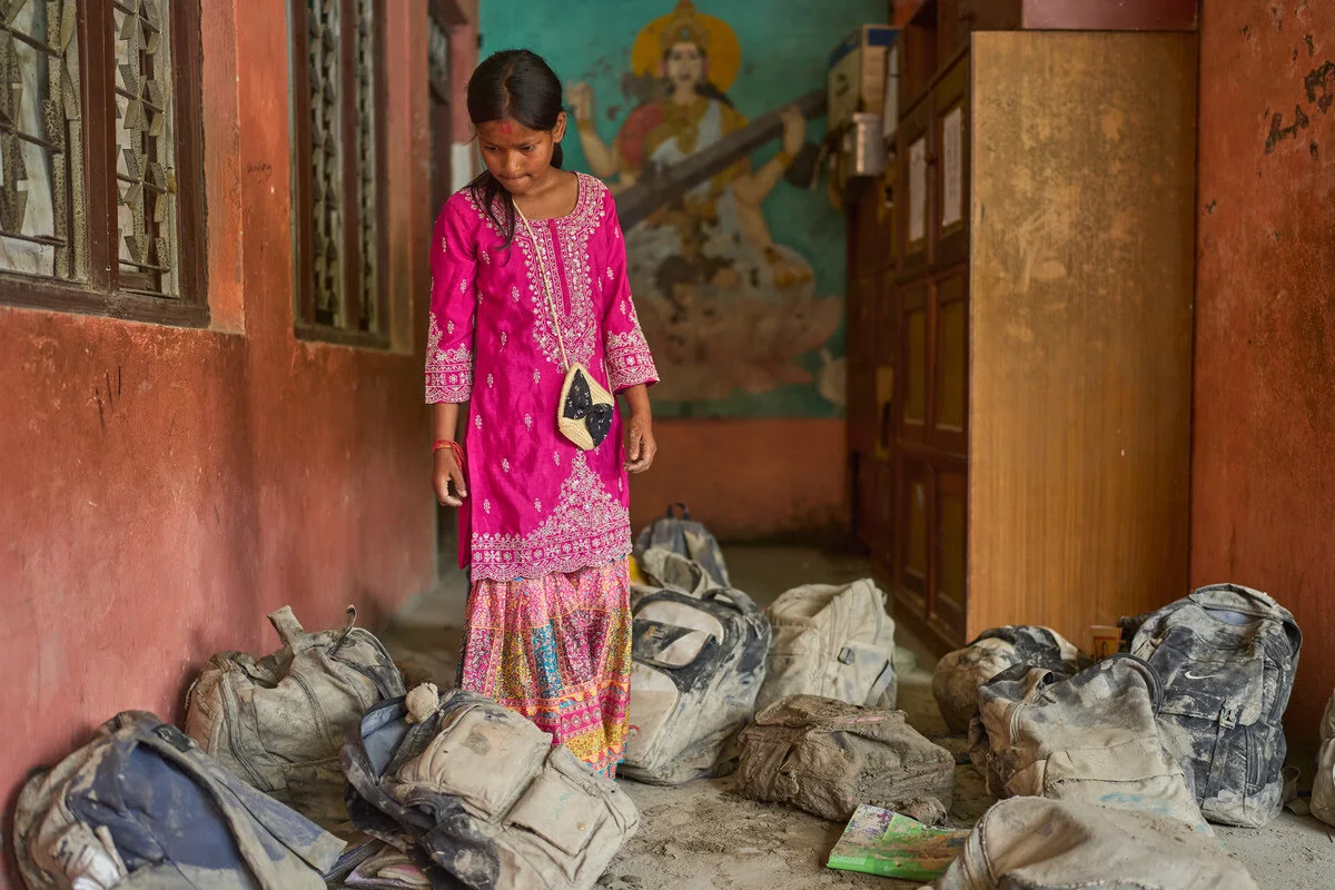 Sturzflut Nepal Eine Schülerin sucht nach der schweren Sturzflut in Nepal ihrer Schultasche im Schlamm.